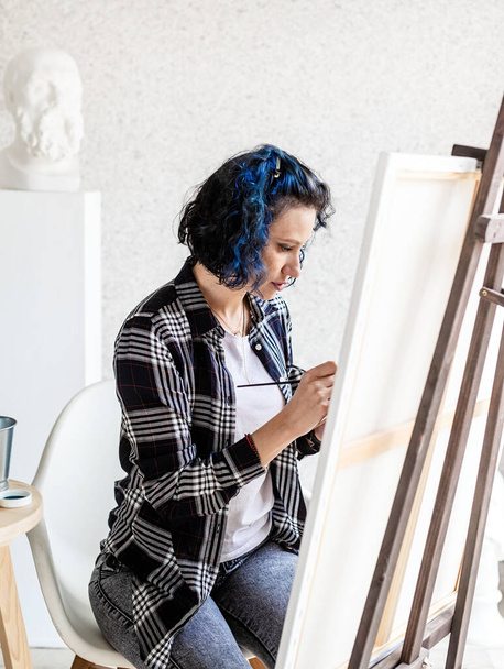 Kreatív nő művész festmény egy képet dolgozik a stúdióban - Fotó, kép