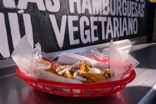 Fritos e cebolas em uma cesta de plástico com palavras por trás - Foto, Imagem