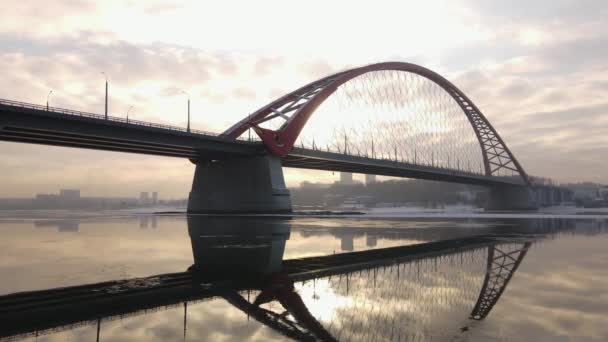 Günbatımı gökyüzünün arka planına karşı Bugrinsky Köprüsü 'nün alt manzarası. Köprü nehre yansıyor. - Video, Çekim