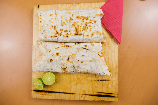 Quesadillas et une tranche de chaux sur une planche à découper - Photo, image