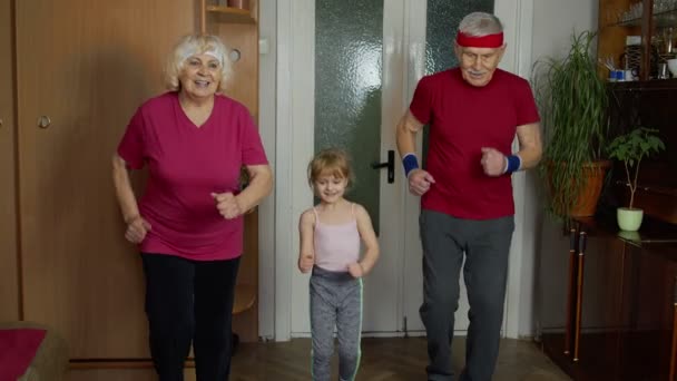 Внучка и взрослые бабушки и дедушки в спортивной одежде - Кадры, видео
