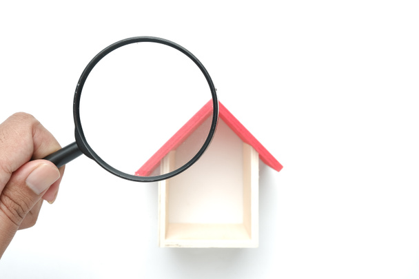 Een foto van vergrootglas inspecteren miniatuur huis dak. Op zoek naar onroerend goed en huis inspectie concept. - Foto, afbeelding