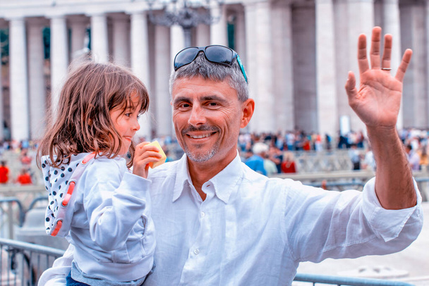 Ο μπαμπάς κουβαλούσε την κόρη της στους ώμους του στην πλατεία Βατικανού. - Φωτογραφία, εικόνα