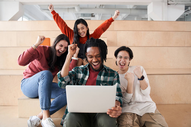 Smiling diverse students looking at the laptop - Фото, зображення