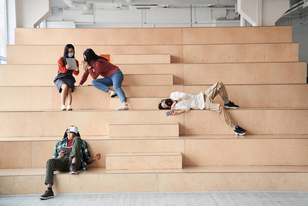 Attractive groupmates spending time together at the stairs - Foto, Imagem