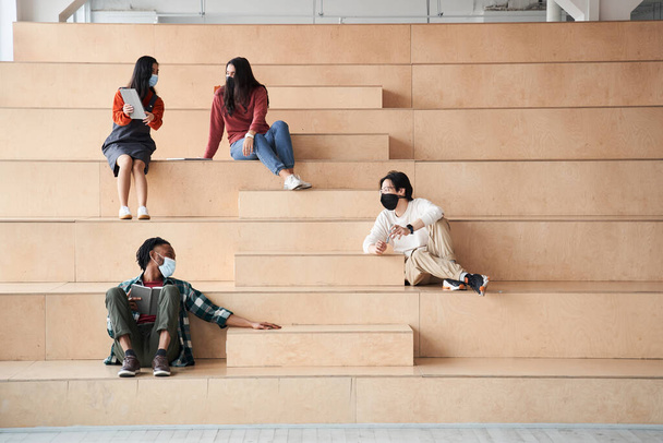 Friendly groupmates speaking with each other at the stairs - Foto, Imagen