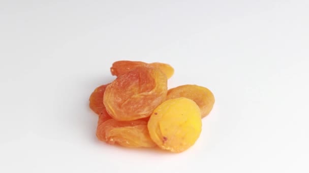 Getrocknete Aprikosen in Nahaufnahme auf weißem Hintergrund. Nützliche Trockenfrüchte. Selektiver Schuss. - Filmmaterial, Video