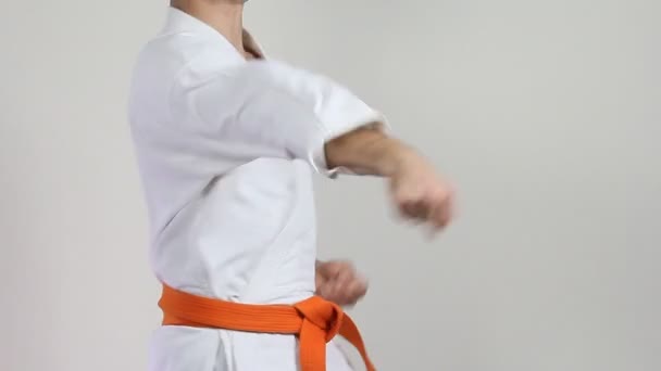 Na bílém pozadí karateka udeří pažemi - Záběry, video