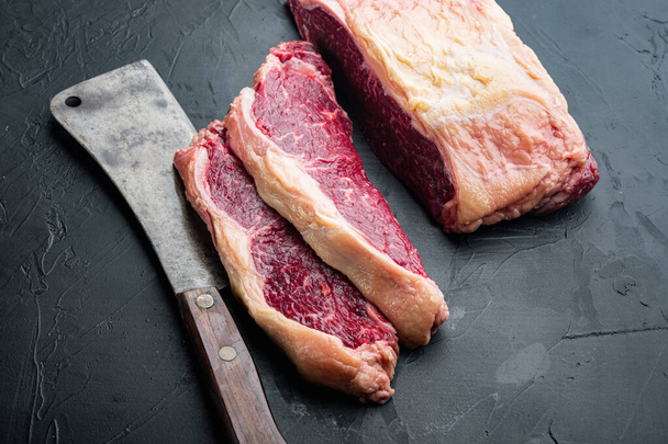 ストリップロースステーキ,生の霜降り牛肉肉,黒を背景に,テキストのためのコピースペースと - 写真・画像