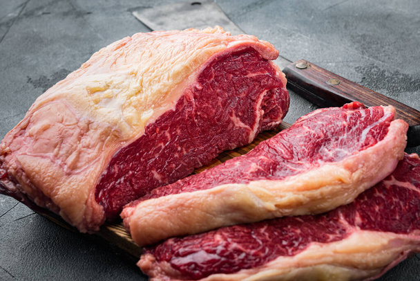 Striploin-Steak roh geschnittenes Rindfleisch, auf grauem Hintergrund - Foto, Bild