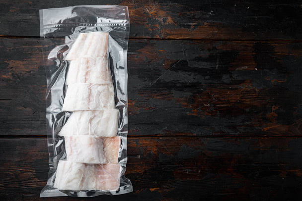 Raw haddock fish skinless plastic vacuum packaged, on old wooden table, top view with copy space for text - Photo, Image