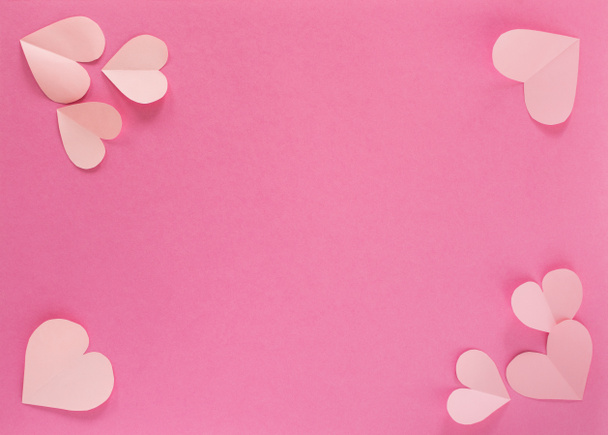 Cuori di carta rosa pastello su sfondo rosa. il concetto di romanticismo, amore e tenerezza. Biglietto d'auguri luminoso per San Valentino. Progettazione dell'anniversario della festa della mamma. La vista dall'alto. - Foto, immagini