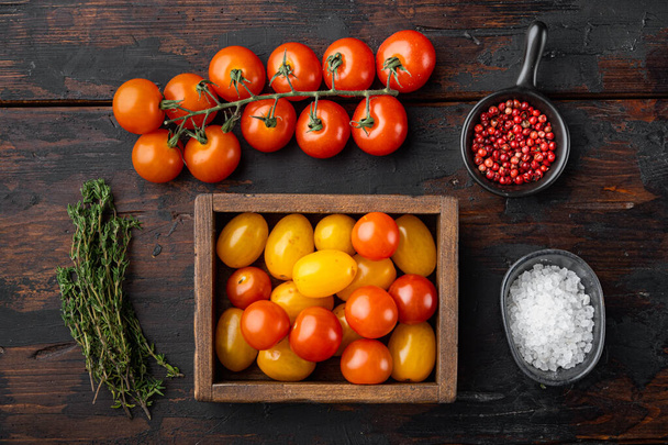 Tomates cereja de cor mista em caixa de madeira, na mesa de madeira velha, vista superior - Foto, Imagem