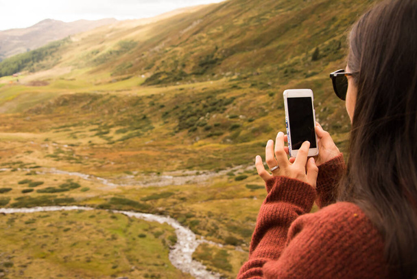 Kobieta robi zdjęcie ze smartfonem pejzażu w Szwajcarii - Zdjęcie, obraz