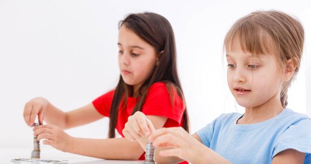 Two kids counting coins together - Photo, Image