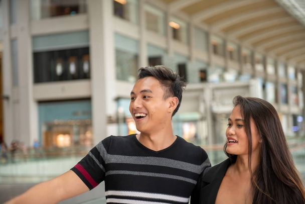 Ευτυχισμένο ζευγάρι επισκέπτονται εμπορικό κέντρο εμπορικό κέντρο, το περπάτημα και χαμογελώντας. - Φωτογραφία, εικόνα
