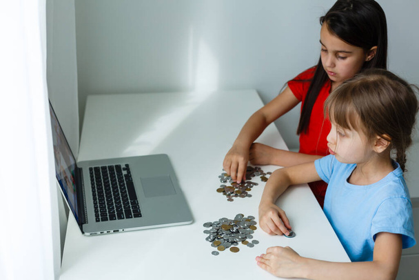 Two kids counting coins together - Foto, Imagem