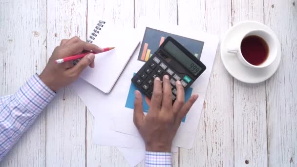 vista superior do homem mão usando calculadora e escrita no bloco de notas  - Filmagem, Vídeo