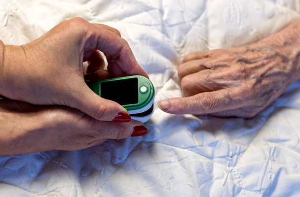 Assessment of the respiratory system function. measurement of blood saturation and pulse in an elderly patient using a pulse oximeter. health and medicine - Foto, immagini
