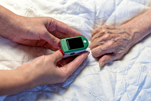 Assessment of the respiratory system function. measurement of blood saturation and pulse in an elderly patient using a pulse oximeter. health and medicine - Фото, зображення