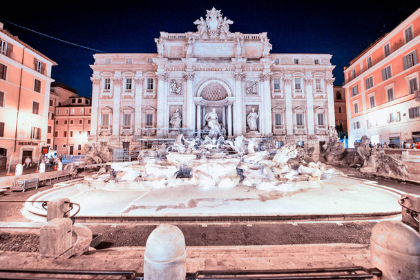 ROMA, ITALIA - JUNIO 2014: Los turistas disfrutan de la hermosa Fontana de Trevi en una noche de verano. - Foto, Imagen