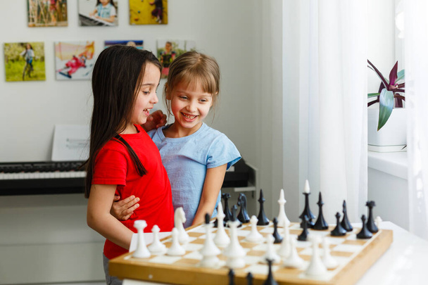 Dos lindos niños jugando ajedrez en casa - Foto, imagen