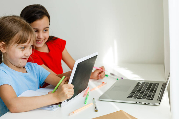 Ziemlich stylische Schulmädchen lernen während ihres Online-Unterrichts zu Hause, soziale Distanz während der Quarantäne, Selbstisolierung, Online-Bildungskonzept - Foto, Bild