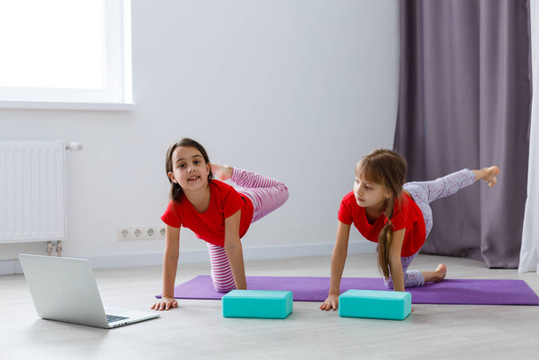 Güzel atletik genç kızlar evde yoga yapıyorlar. - Fotoğraf, Görsel