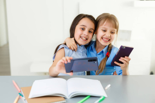 Dwie małe dziewczynki uczą się w sieci. Nauka na odległość online, e-learning, koncepcja - Zdjęcie, obraz