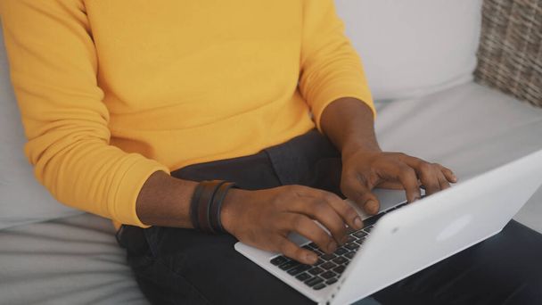 Close-up, zwarte man met laptop. Het begrip telewerk of afstandsonderwijs - Foto, afbeelding