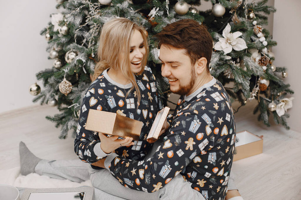Cute couple at home near christmas tree - Foto, Imagen