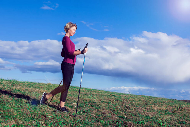 Nordic Walking, Bewegung, Sport, Abenteuer, Wanderkonzept - eine Frau wandert in der Natur - Foto, Bild