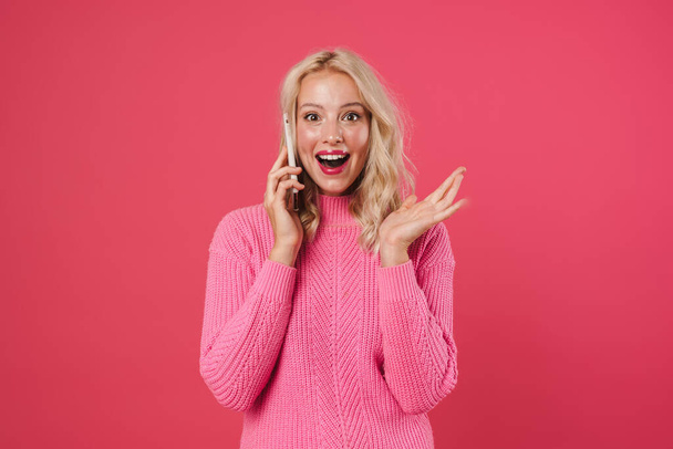 Happy young woman talking on the phone isolated on pink background - Foto, immagini