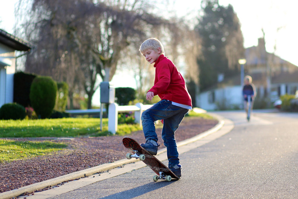 Boy learning to balance on skateboard on the street - Photo, image