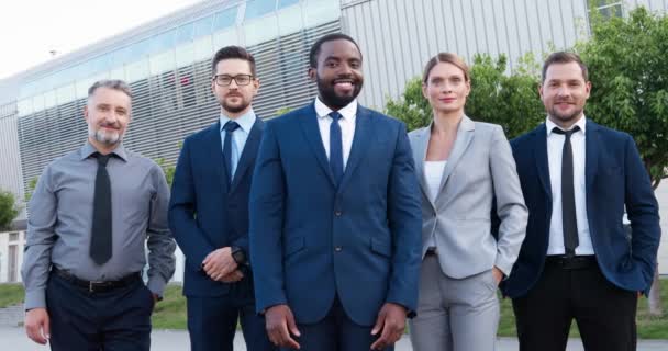 Portrét úspěšného bohatého mladého afroamerického šéfa s týmem multietnických mužů a kolegyň. Smíšené rasy obchodníci a obchodnice se usmívají kamerou ven. Happy colleagues - Záběry, video