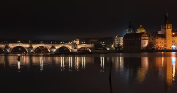 az idő múlásával kilátás nyílik a Károly hídra és a folyó Moldva folyóra éjjel Prága központjában, a Cseh Köztársaságban - Felvétel, videó