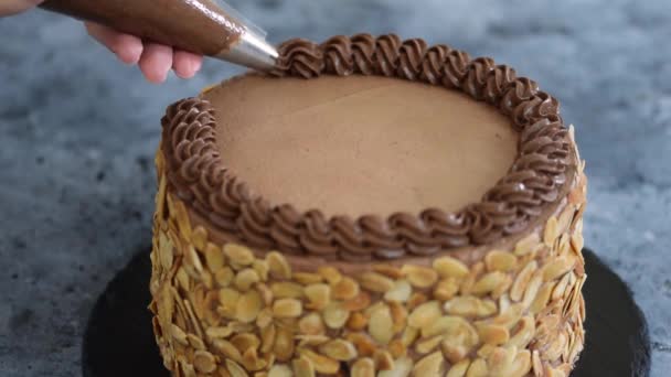 Chef decorando pastel de chocolate con crema. - Imágenes, Vídeo