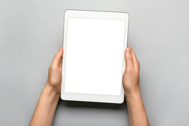 Hands with tablet computer on gray background - Photo, image