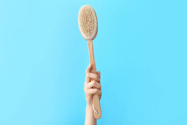 Hand with massage brush on color background - Photo, Image