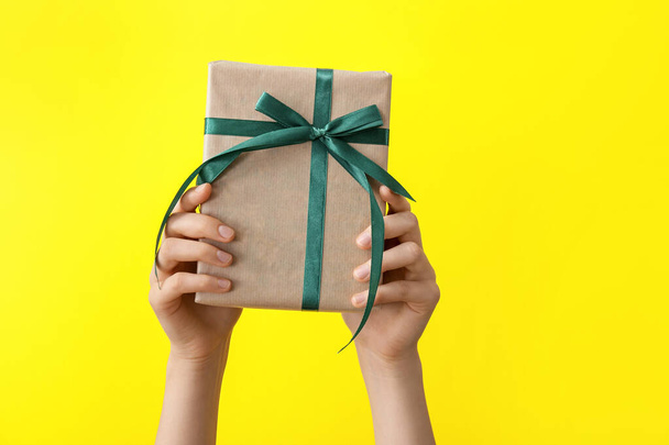 Hands with gift box on color background - Φωτογραφία, εικόνα