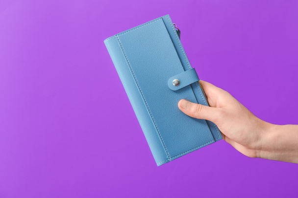 Hand mit Geldbörse auf farbigem Hintergrund - Foto, Bild