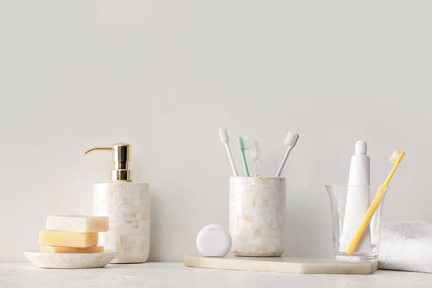 Houders met tandenborstels en tandpasta op tafel in de badkamer - Foto, afbeelding