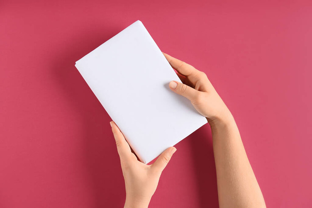 Female hands with blank book on color background - Photo, Image