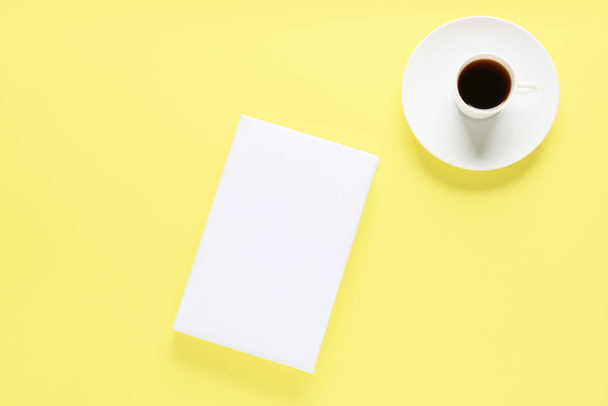 Blank book and cup of coffee on color background - Фото, изображение