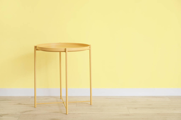 Stylish table near color wall in room - Fotoğraf, Görsel