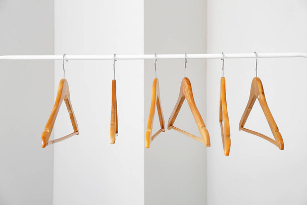 Rack with clothes hangers on light background - Photo, Image