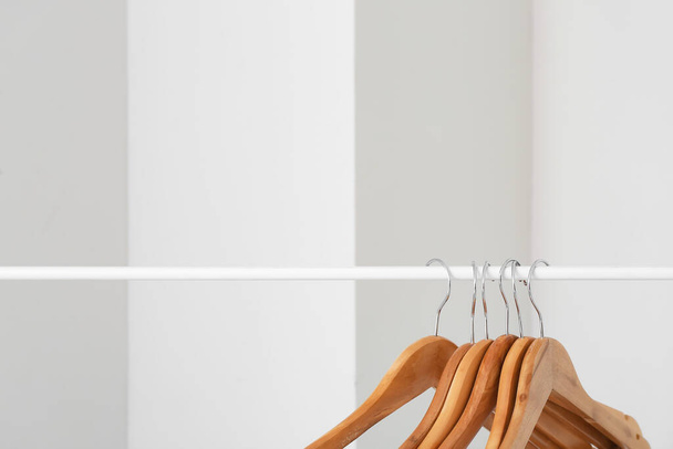 Rack with clothes hangers on light background - Foto, imagen