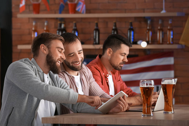 Szczęśliwi mężczyźni po wygraniu zakładów sportowych w pubie - Zdjęcie, obraz