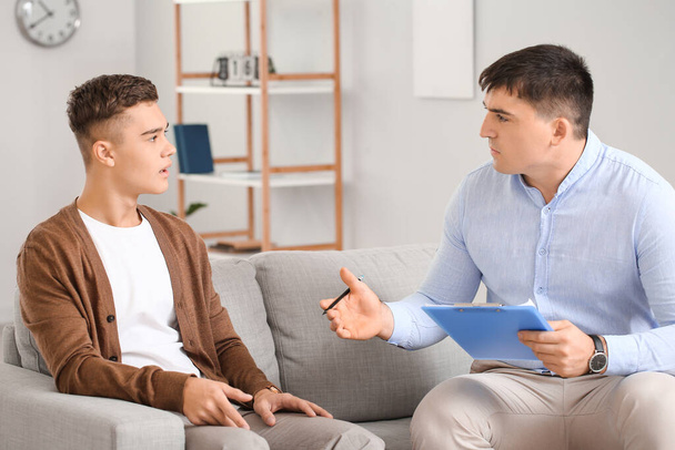 Psychologist working with teenage boy in office - Photo, Image