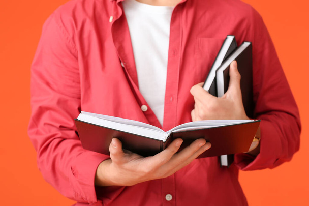 adolescent garçon avec livres sur couleur fond, gros plan - Photo, image